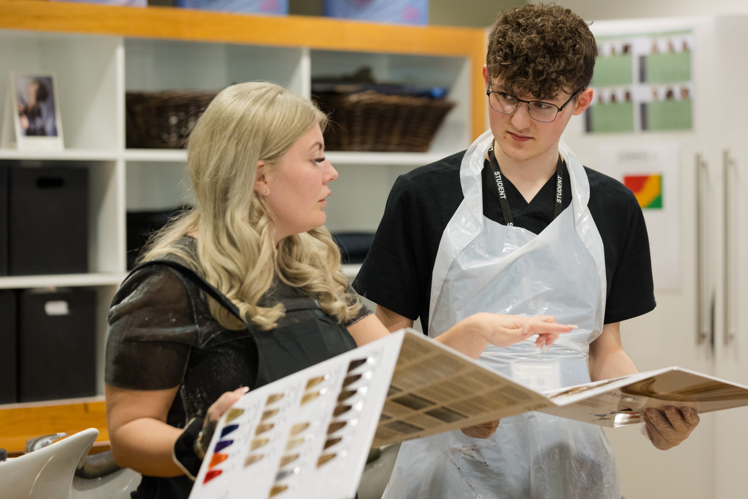 hairdressing tutor teaching student hair colour swatches