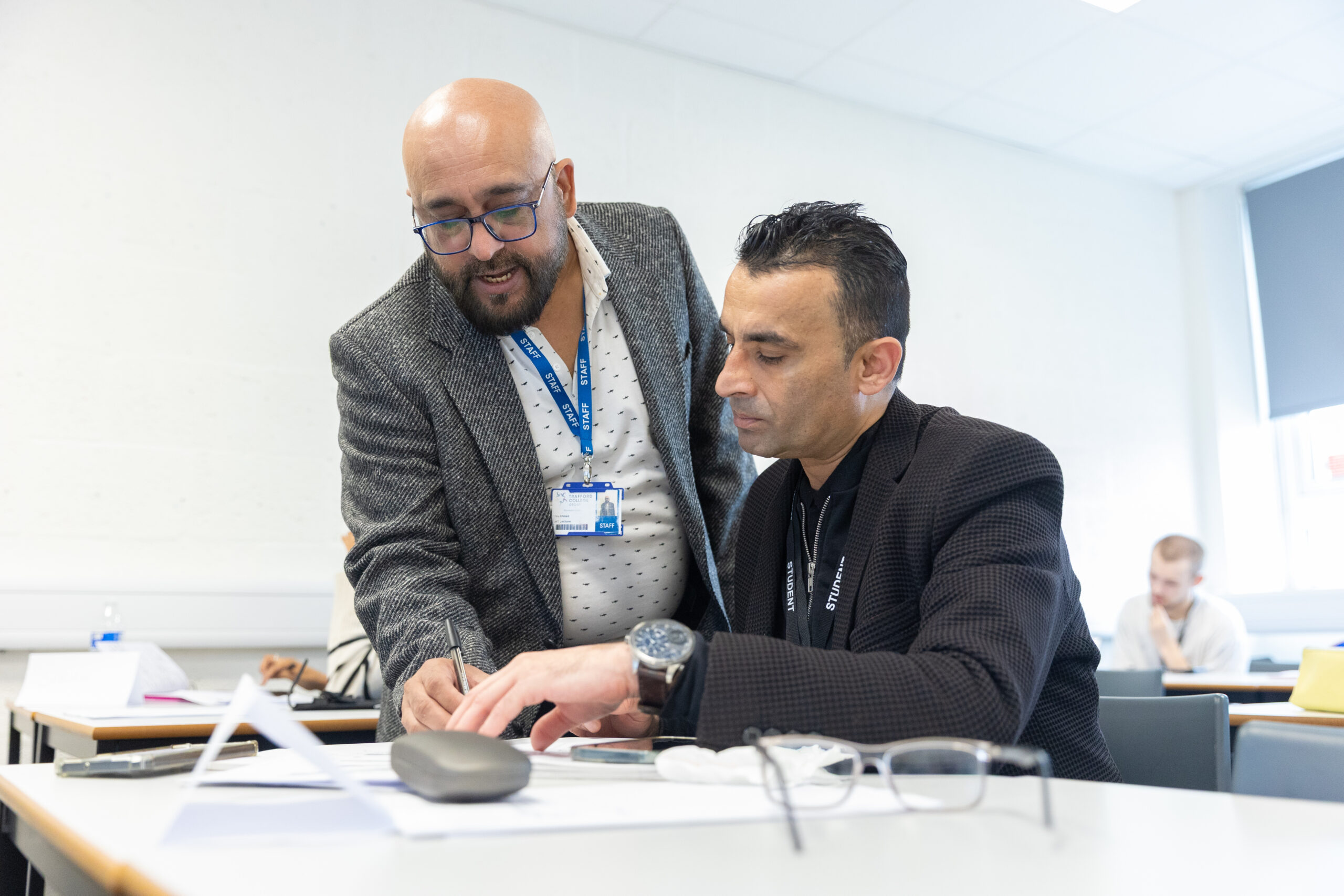 Adult student looking at work with a teacher